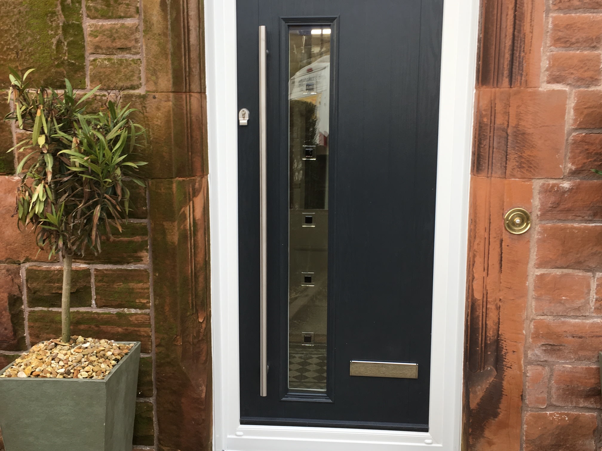 Charcoal door with a tall glazed panel.